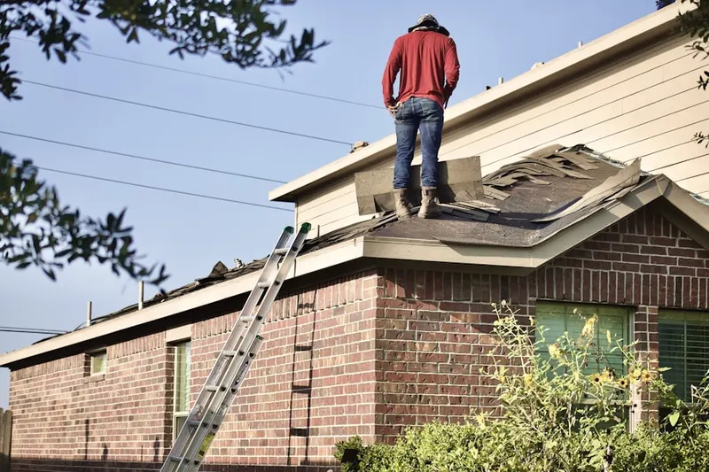 Professional roofer working on a residential roof in Nevins